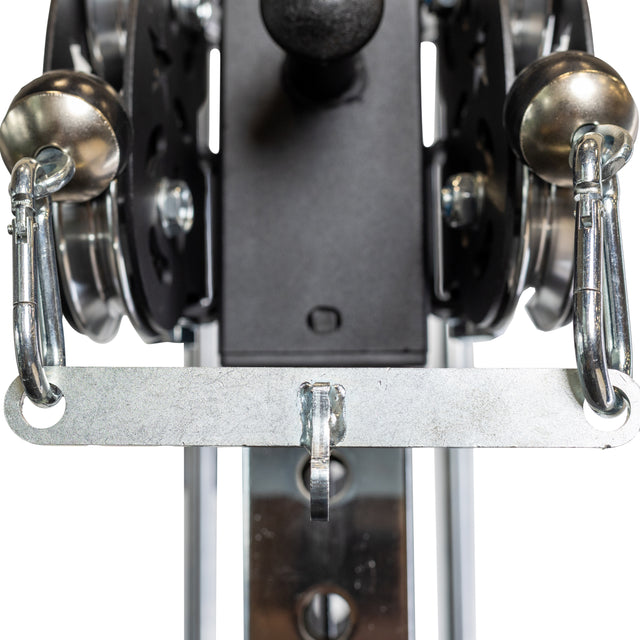 Close-up of the Bells of Steel 2 to 1 Cable Attachment Adapter featuring metal carabiners, pulleys, and a metal attachment bar for weight training exercises.