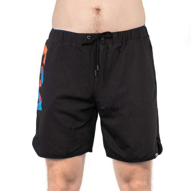 A person is wearing Bells of Steel Gym Shortsâblack with a drawstring waist and colorful geometric design on the left side, made from stretchy fabricâshown from waist to above the knees against a white background.