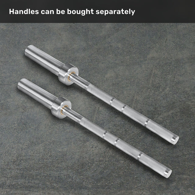 Two silver Anvil Handles by Bells of Steel are placed side by side on a gray textured surface. Text at the top reads, “Handles can be bought separately.”.