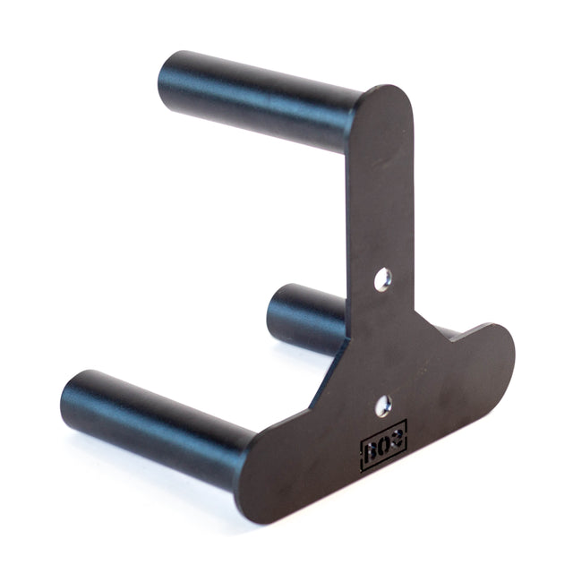 The Bells of Steel Change Plate Storage Pegs feature a black metal wall-mount design with two cylindrical arms and a flat backplate with mounting holes, plus a small engraved logo—similar to Olympic change plate pegs.
