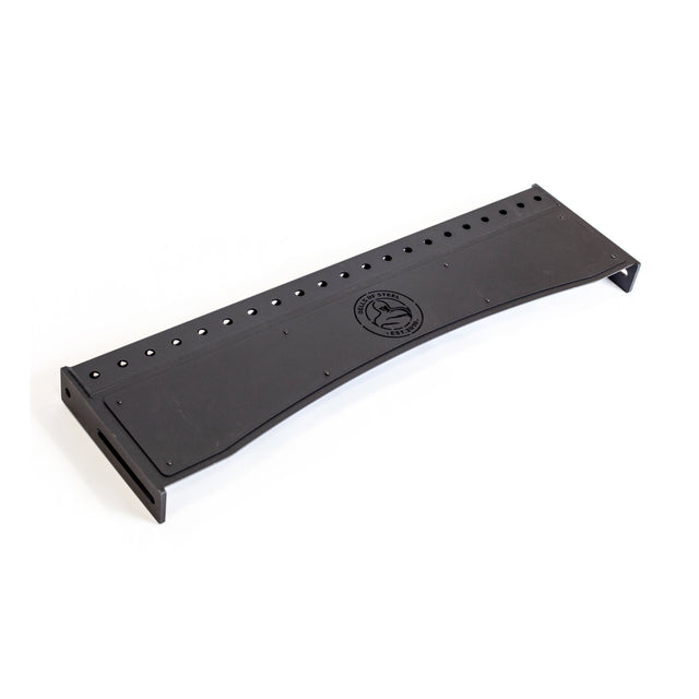 A black, rectangular Bells of Steel Logo Plate Crossmembers board features multiple holes along the top edge and a central Manticore Rack wolf logo. The board has a slight curve with angled ends for enhanced functionality.
