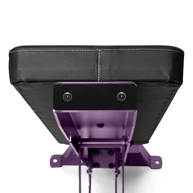 A close-up of the Buzz-Saw Heavy-Duty Adjustable Bench by Bells of Steel shows a black cushioned seat connected to a purple metal frame. The rugged design includes a bracket with bolts, viewed from below.