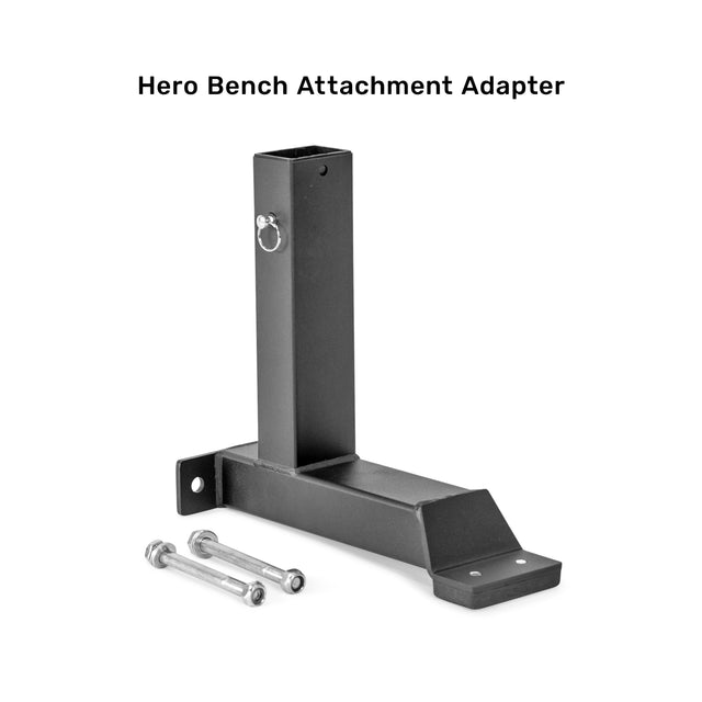 A black metal Bells of Steel Bench Attachments adapter, compatible with Buzzsaw Bench and other attachments, is shown on a white background with two bolts and nuts. Text above reads "Hero Bench Attachment Adapter.