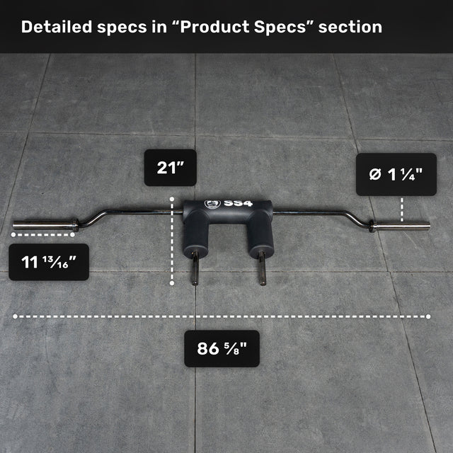 The Bells of Steel Safety Squat Bar - The SS4, featuring padded handles, rests on a gray tiled floor. Text boxes show: 86 5/8" length, 21" width, 1 1/4" sleeve diameter, and 11 13/16" handle spacing.
