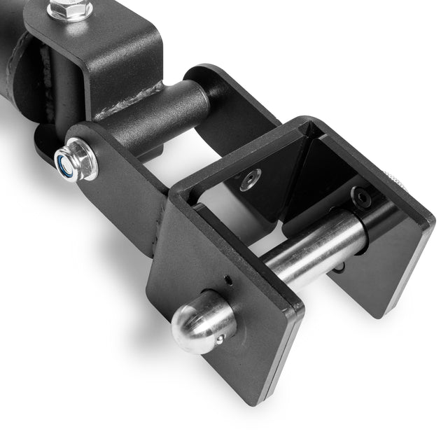 Close-up of the Bells of Steel Landmine Rack Attachment, a robust black metal hinge with bolts and a cylindrical rod, designed for heavy-duty use, set against a white background.