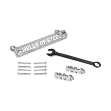 The Bells of Steel Manticore Hardware kit includes a labeled metal bar, black wrench, bolts, nuts, screws, and concrete anchor bolts—everything you need to assemble your Manticore Power Rack on a white surface.