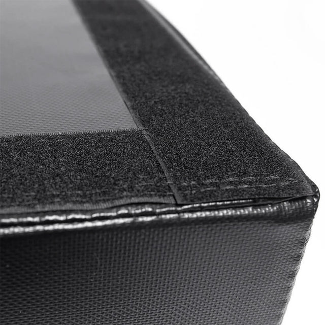 Close-up of Bells of Steel Deadlift Pads (Pair)—black, textured, rectangular pads with a smooth, shiny surface and Velcro strip along the edge—ideal for deadlifting. Set against a white background.