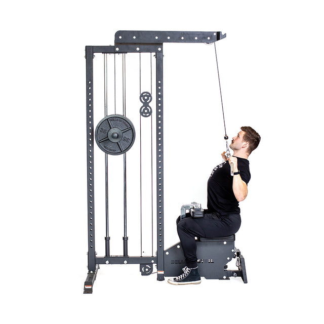 A man in black athletic wear performs a lat pulldown on the Bells of Steel Lat Pulldown Low Row Machine with weight plates, showcasing effective cable exercises against a white background.