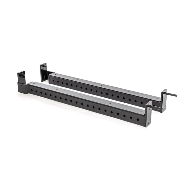 The Bells of Steel Flip-Down Safeties are adjustable black metal beams with evenly spaced holes, angled brackets on both ends, and a small handle—engineered for safe power rack training.