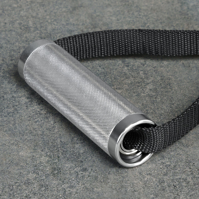 The Bells of Steel Aluminum Handles Pair with Bearings features a knurled metal grip, silver end caps, and attaches to a thick black strap, shown resting on a gray stone surfaceâideal as a gym handle attachment.