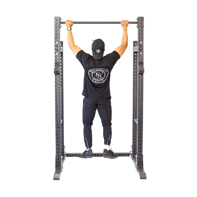 Using the sleek Bells of Steel Straight Pull Up Bar, a person in black athletic attire demonstrates their dedication to fitness against a white backdrop.