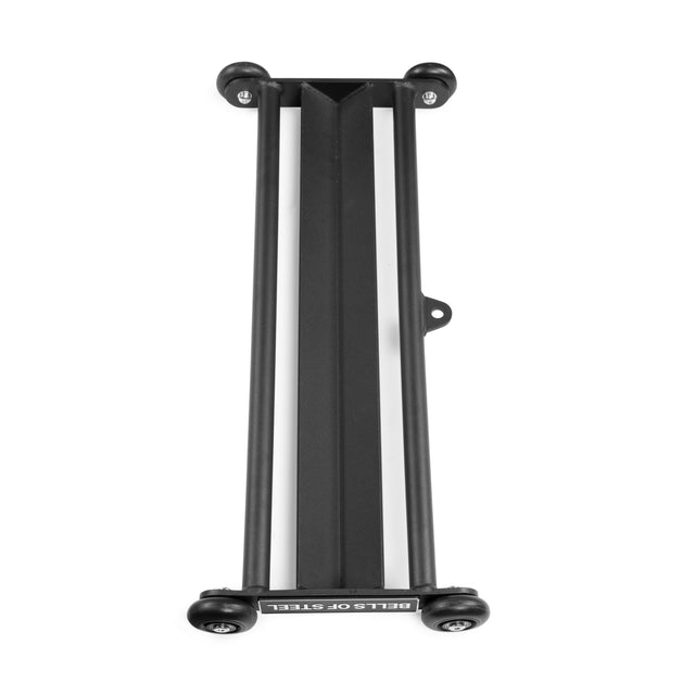 The Glute Ham Slider by Bells of Steel is a black metal bike storage rack on wheels with a V-shaped center channel and two parallel side bars, reminiscent of gym gear. "BELLS OF STEEL" is printed on one end. Photographed on a white background.