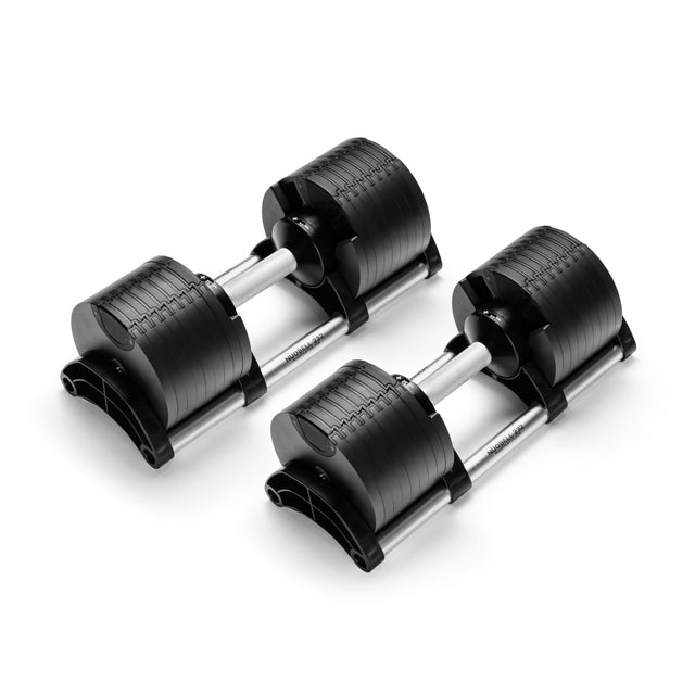 The Nuobell NÜOBELL Adjustable Dumbbells feature a patent-pending design with black machined steel plates, silver handles, and matching black trays, displayed on a white background.