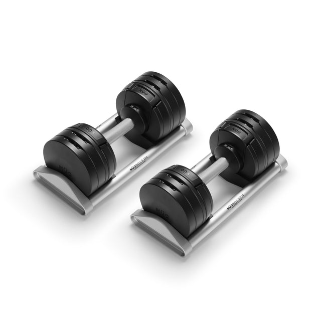 The Bells of Steel NÜOBELL-S Adjustable Dumbbells, featuring round plates on sleek silver trays, deliver precision and style to your home gym—all set against a crisp white background.