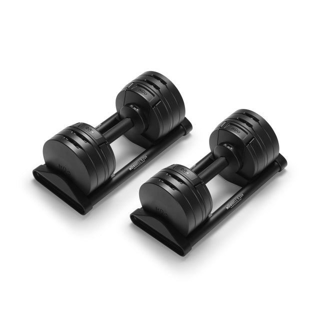 A pair of Bells of Steel NÜOBELL-S Adjustable Dumbbells rests on trays, each featuring multiple weight plates, displayed against a white background.
