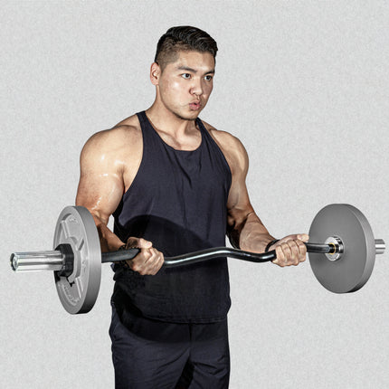 A person wearing a black tank top lifts a barbell with weight plates, performing a bicep curl. Their expression shows focus and effort. The background is plain gray.