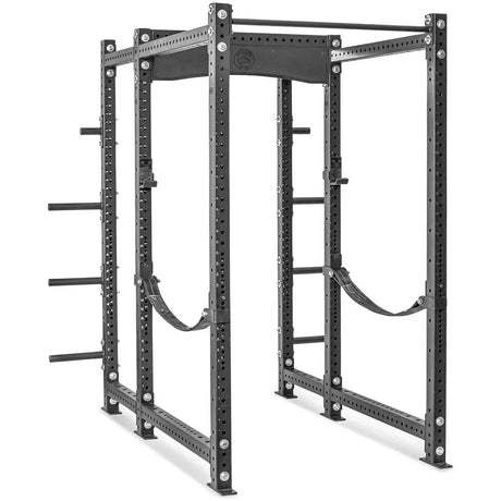 A large black metal power rack with multiple holes for adjustments, safety straps, and weight plate storage pegs, designed for weightlifting and strength training exercises.