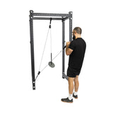 A person in black athletic wear uses the Bells of Steel Tricep Rope Extension with a cable pulley machine for a triceps workout, standing on a white background.