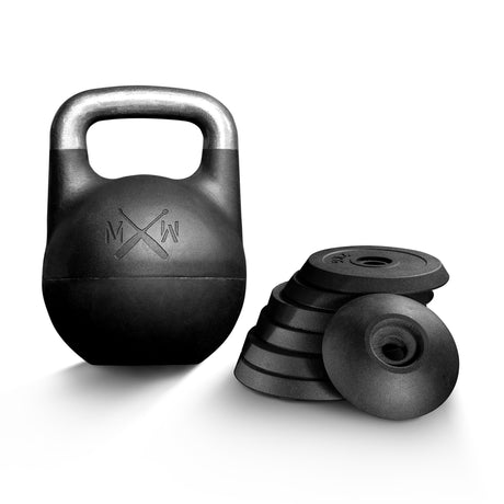 The Bells of Steel Mark Wildman Adjustable Kettlebell, featuring a black competition-style body with a silver handle, stands upright beside a stack of circular black weight plates on a white background—ideal for functional training routines inspired by Mark Wildman.