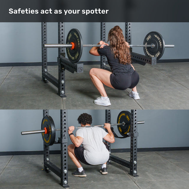 Two people perform barbell squats in a Bells of Steel Manticore Four Post Power Rack Builder (3" x 3", 1" Holes)—the sturdy rack’s safety bars set at knee height. The text above reads, "Safeties act as your spotter." Perfect for any home gym setup, this power rack ensures both safety and strength during your workouts.