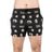 A person stands against a white background wearing black Bells of Steel Gym Shorts with white logos, "BOS," brand text, and graphic designs made from high-performance materials.