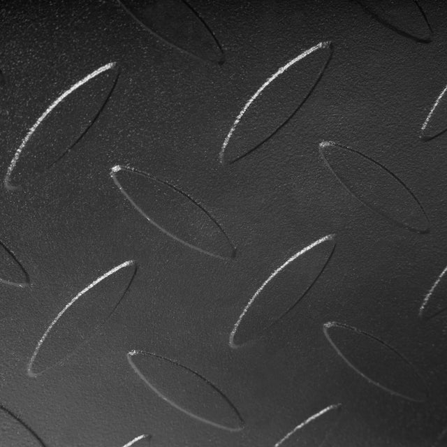 Close-up of a black metal surface with a repeating raised oval tread pattern, like that found on the Bells of Steel Footplate for Cable Tower/All In One Trainer, providing added grip and safety.