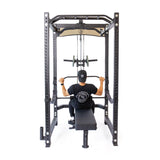A person sits on a bench facing a weight machine, gripping the Bells of Steel Lat Pulldown & Low Row Rack Attachment – Hydra & Manticore with both hands, ready to work out. The scene is viewed from behind against a white background.