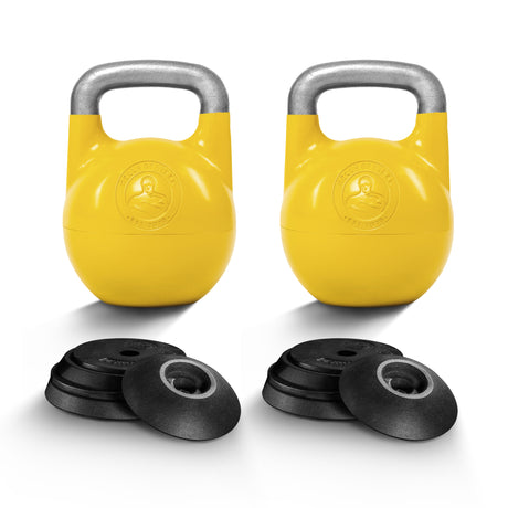 Two yellow Bells of Steel Adjustable Competition Kettlebells with silver handles, each featuring a front emblem, are displayed behind sets of black weight plates on a white background. Ideal for kettlebell training.