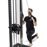 A person kneels on one knee while performing a cable face pull at the gym, gripping Bells of Steel Aluminum Handles Pair with both hands.