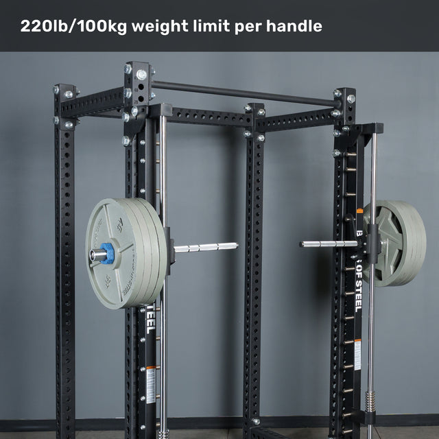 A power rack with a loaded barbell and weight plates on each side, featuring Bells of Steel Anvil Handles for optimized grip and control. Text above reads “220lb/100kg weight limit per handle.” The setup is in a gym with a gray wall in the background.