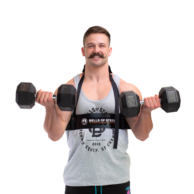 A man with a mustache in a gray tank top uses the Bells of Steel Arm Blaster to perform bicep curls with two black dumbbells, standing against a white background.