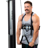 A man with a mustache, dressed in a gray tank top and black shorts, uses the Bells of Steel Arm Blaster for an intense arm workout. He holds the equipment with both hands, ready for biceps training against a white background.