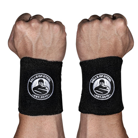 Two fists display BellGuard Kettlebell Wrist Guards by Bells of Steel, black with a white logo and “EST. 2010” embroidery—ideal protection for serious kettlebell lifters.