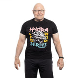 A smiling older man with glasses wears a black Bells of Steel Bamboo T-Shirt featuring colorful "Hydra Beast Series" text and a dragon graphic, standing against a white background.