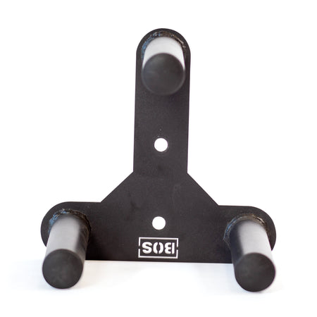 The Bells of Steel Change Plate Storage Pegs is a black metal wall mount with three cylindrical pegs in a triangular layout for holding Olympic change plates. It features two mounting holes and an upside-down "SIS" logo at the base.