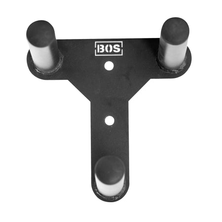 The Change Plate Storage Pegs, a black, T-shaped wall mount from Bells of Steel featuring three cylindrical pegs and a "BOS" logo on top, are perfect for organizing resistance bands, belts, or Olympic change plates.
