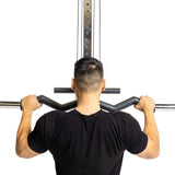 A person in a black shirt is seen from behind using the Fat Bar - Olympic Curl Bar Cable Attachment by Bells of Steel. Set against a white background, they grip the bar firmly with both hands to enhance grip strength during the exercise.