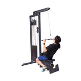 A person in a black shirt and blue shorts uses the Bells of Steel Multi Grip Curl Bar Cable Attachment on a lat pulldown machine, pulling it toward their chest for arm isolation, set against a plain white background.