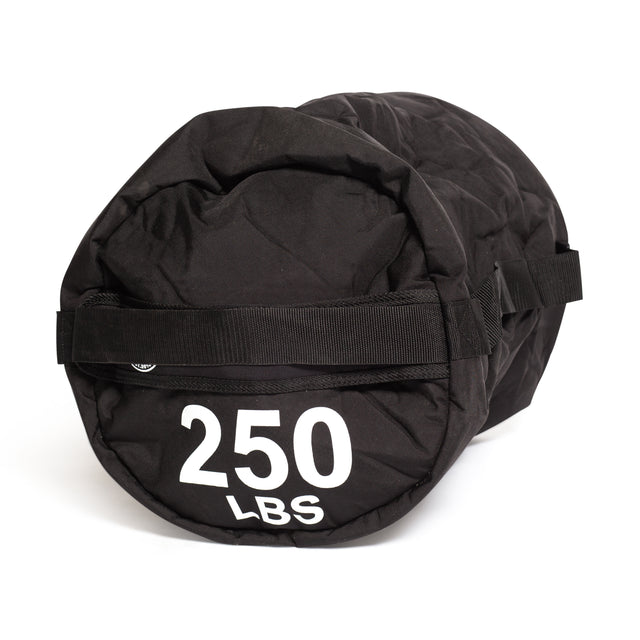 The Bells of Steel Fitness Sandbags is a large black cylindrical bag with a handle, labeled "250 LBS" in white text on the end. It features durable construction and is shown against a white background.