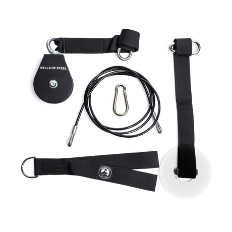 The Bells of Steel Cable Pulley set includes a black pulley, steel carabiner, cable, white loading pin, and black straps with metal rings—ideal for lat pulldowns and tricep pushdowns—displayed on a white background.