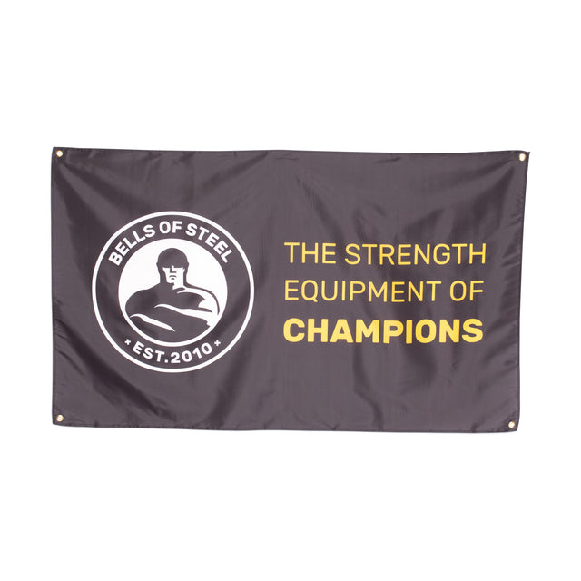 A black Bells of Steel flag featuring its logo on the left and "THE STRENGTH EQUIPMENT OF CHAMPIONS" in bold yellow and white lettering—ideal for gym decor or upgrading your home gym.