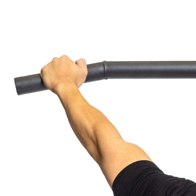 A person wearing a black shirt demonstrates grip strength by holding the Bells of Steel Fat Bar - Lat Pulldown Bar with their right hand against a white background.