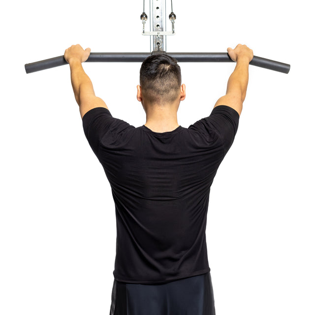 A person in a black shirt grips the Bells of Steel Fat Bar - Lat Pulldown Bar, preparing for exercise and building grip strength against a plain white background.
