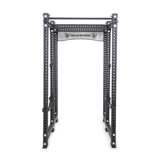 The Manticore Six Post Power Rack Builder by Bells of Steel, featuring modular components, 1" holes for adjustable equipment, and a pull-up bar, displays the brand's logo on the top crossbar. Its sturdy black metal frame is perfect for weightlifting and strength training exercises.