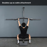 A person sits on a bench facing a wall, holding the Bells of Steel Arch Nemesis Swiss Bar attached to an overhead cable machine, with the caption "Doubles up as cable attachment" above.