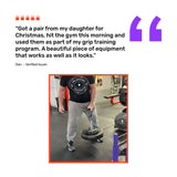 A man in gym clothes uses the Bells of Steel Fat Bar - Single D Handle to lift weight plates. Above him, a customer review appears with a large purple quote mark and five red person icons.