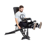 A man in a gray T-shirt and black pants uses a leg extension machine while seated on the Bells of Steel Buzz-Saw Heavy-Duty Adjustable Bench, which features premium vinyl upholstery.