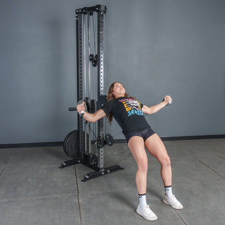A person uses the Bells of Steel Aluminum Handles Pair with Bearings to perform a cable chest fly exercise in a gym, leaning back with arms extended and gripping the adjustable handles. They wear a black t-shirt, shorts, and sneakers.