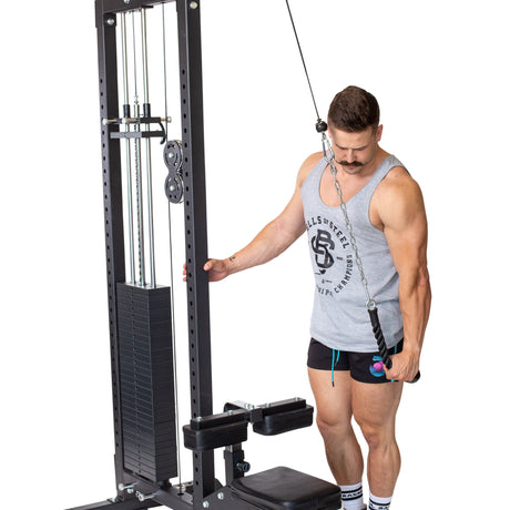 A man in a gray tank top and black shorts uses the Bells of Steel Tricep Pulldown Rope – Single for a tricep pushdown, holding the attachment with one hand while standing on a white background.