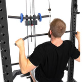 A man grips the Bells of Steel Lat Pulldown & Low Row Rack Attachment (Hydra & Manticore), seated on a workout bench, preparing for cable exercises with visible equipment, weights, and the low row attachment.